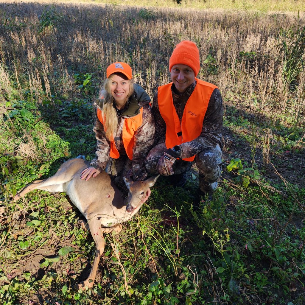 Two hunters pose with harvested deer