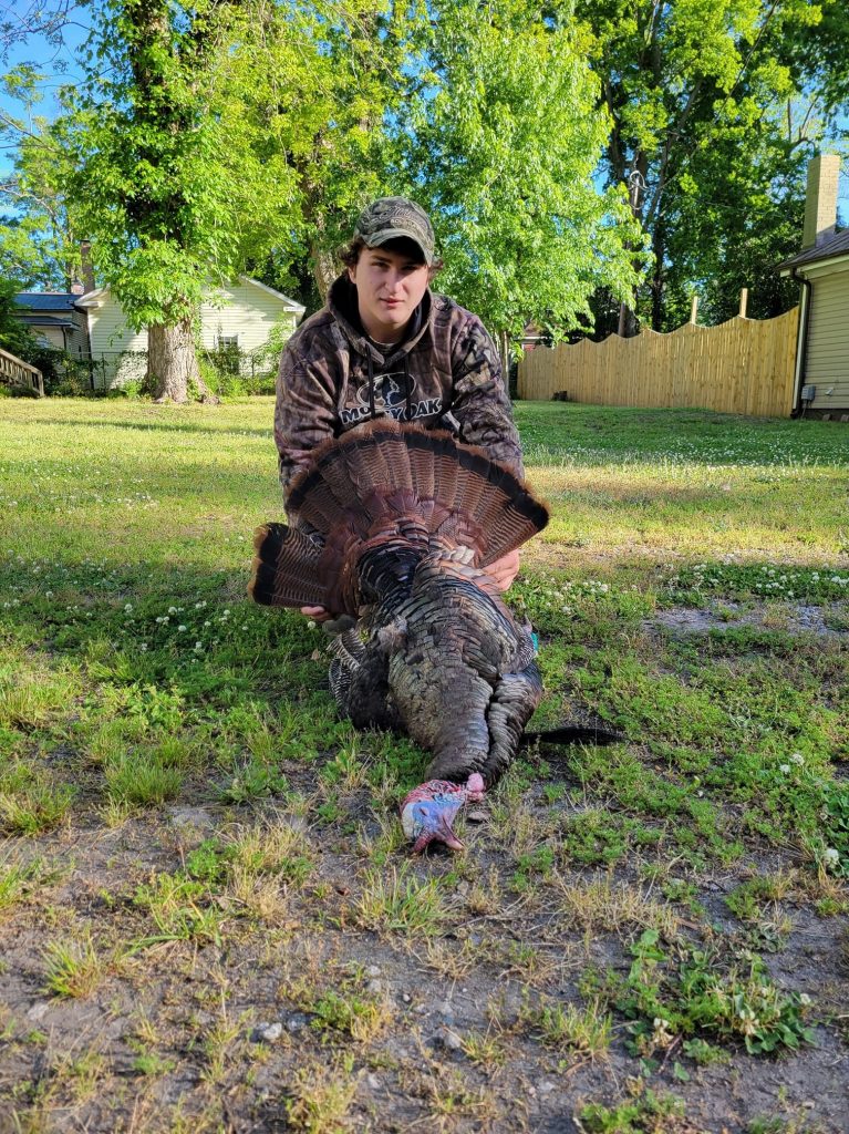 A yuong hunter with his harvested turkey.