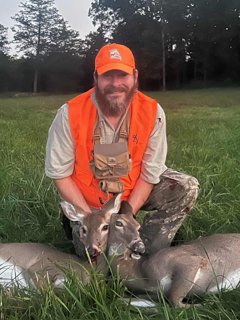 A hunter poses with their recently harvested deer.