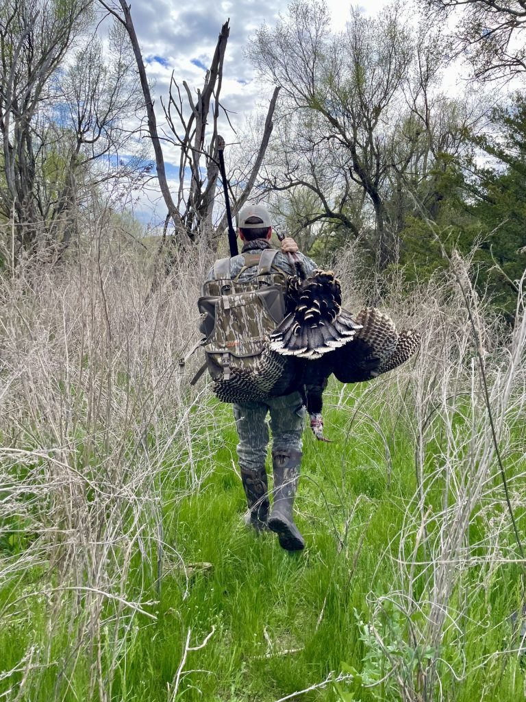 A hunter carries out a turkey with his Alps Impact Pro Turkey Vest 