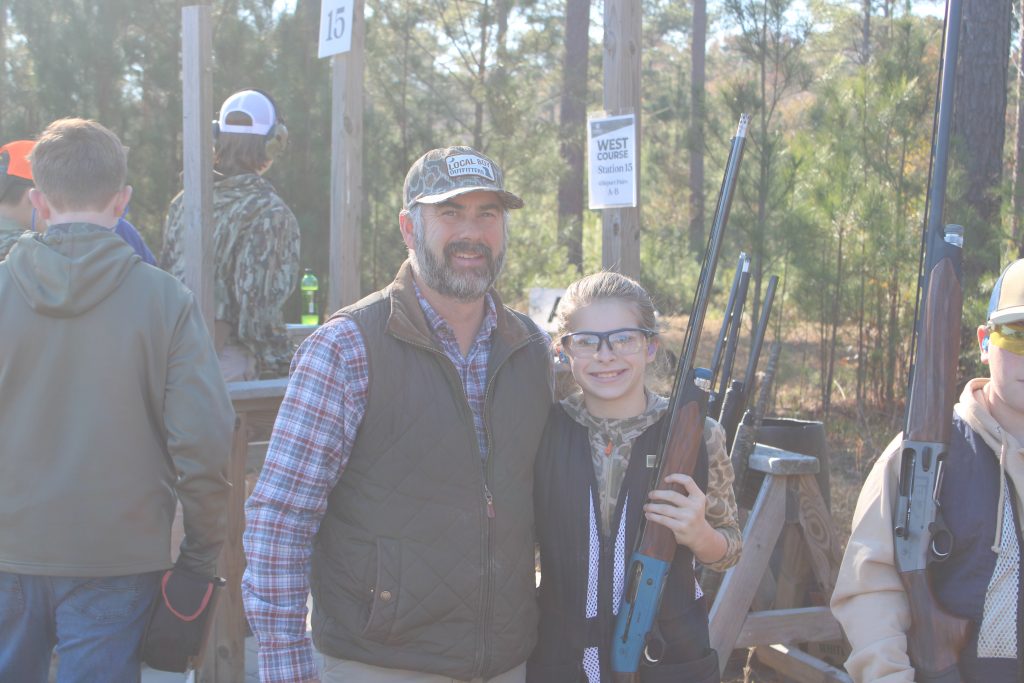 A youth shooter and her mentor pose for a photo.