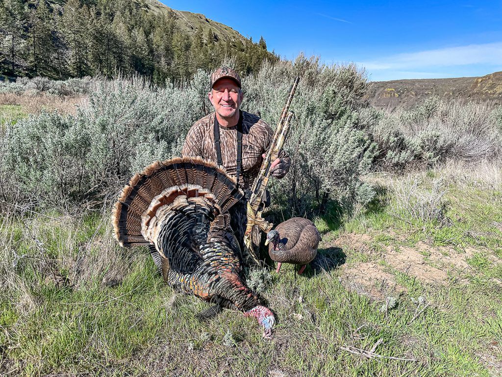 A hunter with a harvested wild turkey.