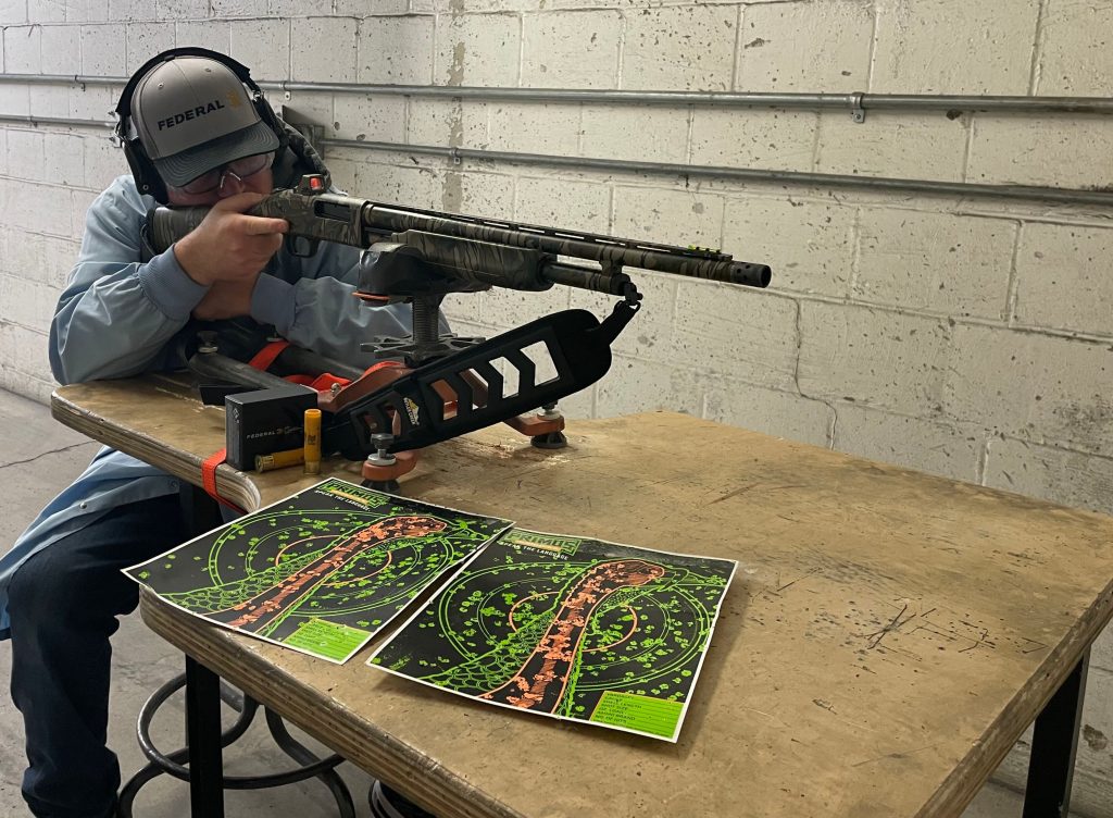 Hunter patterning shotgun at inside shooting range. 
