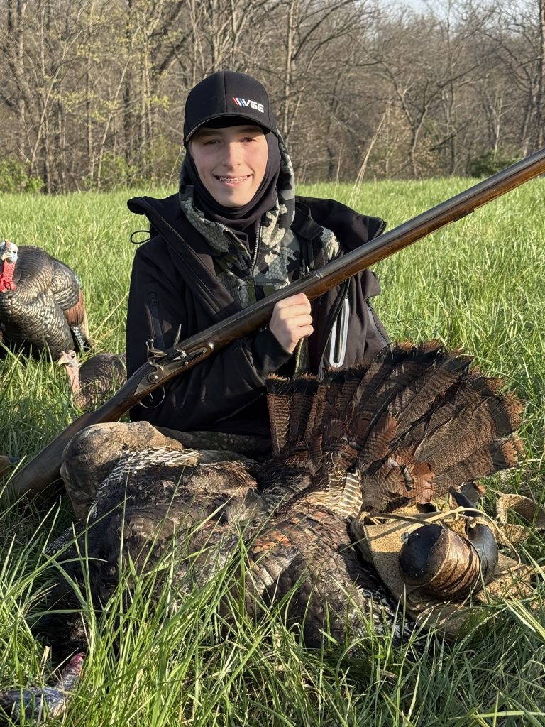 Russell posing with his harvested turkey and flintlock