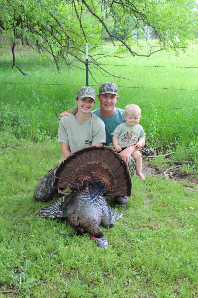 Tanna, her husband Drew and their son River celebrate the harvest of a rare-banded wild turkey