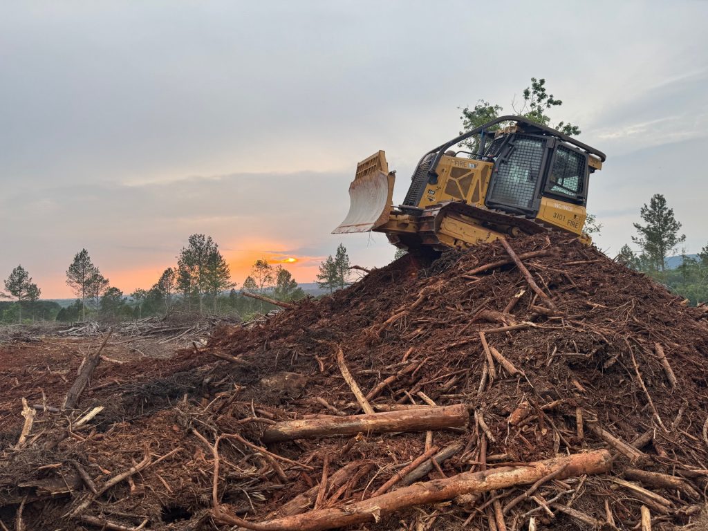 A dozer on top of a large mound.