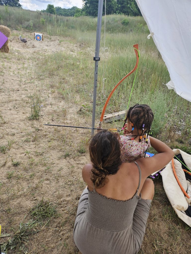 A young girl tries her hand at a bow