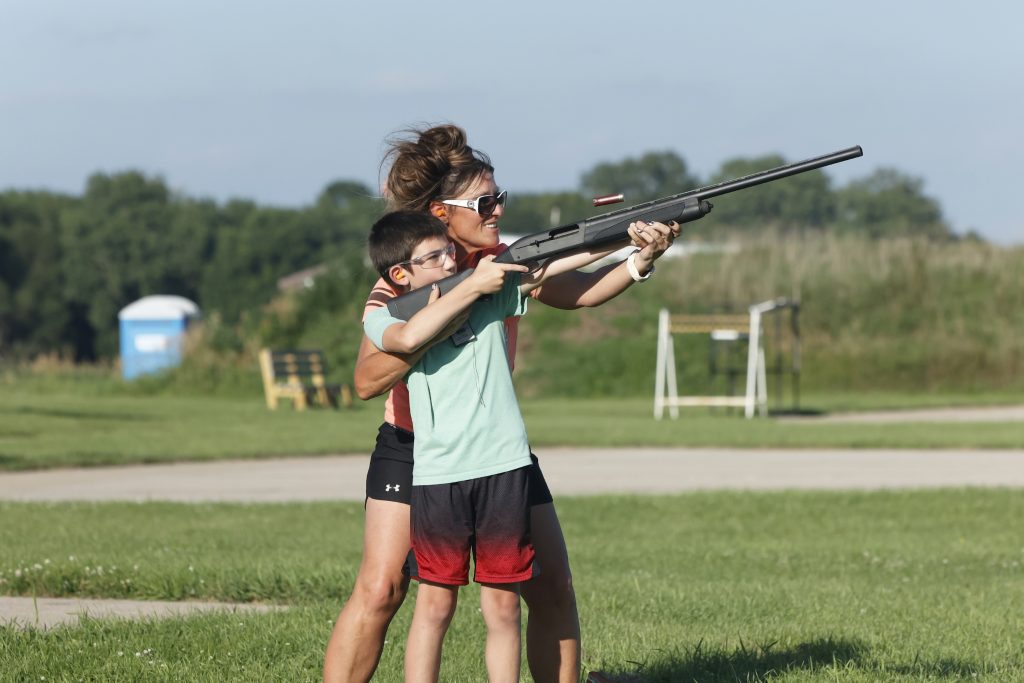 A young participant in the Brandon Boss Gobblers Jakes event gets assistance from one of the volunteers in shooting a shotgun for the first time at clay pigeons.