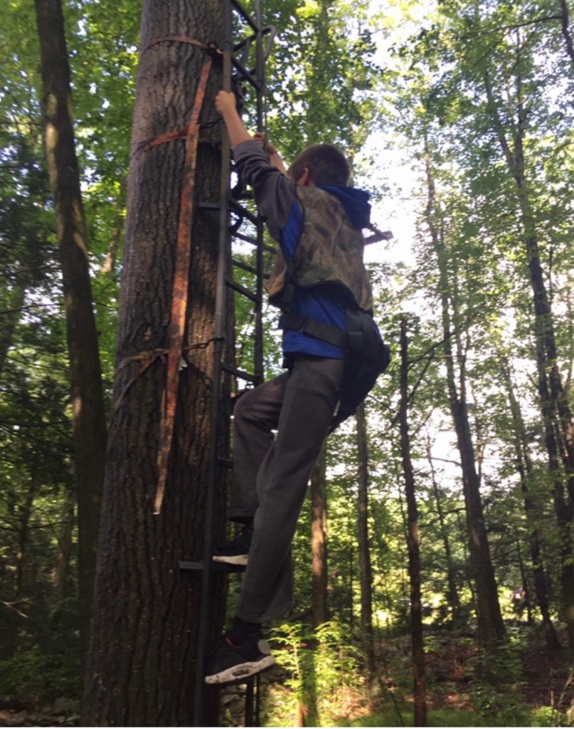 A youth practies tree stand climbing