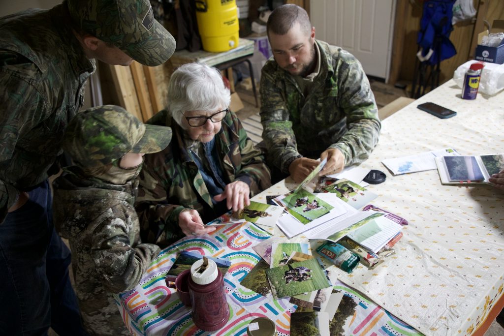 Family gathers and looks at photos.