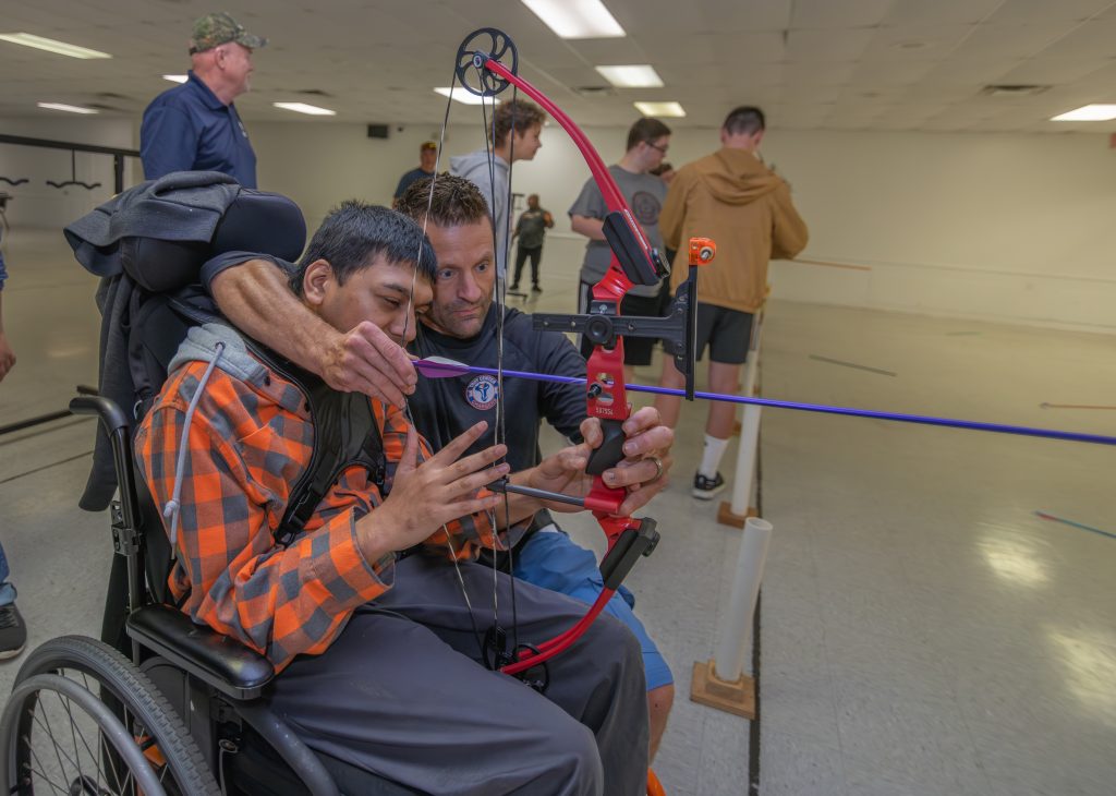 Youth and mentor learn archery