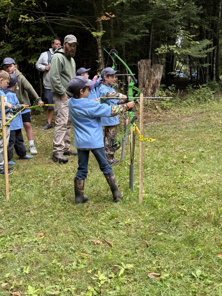 A young attendee at the archery station
