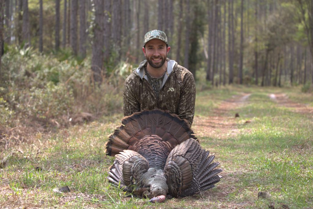 hunter with a harvested wild turkey